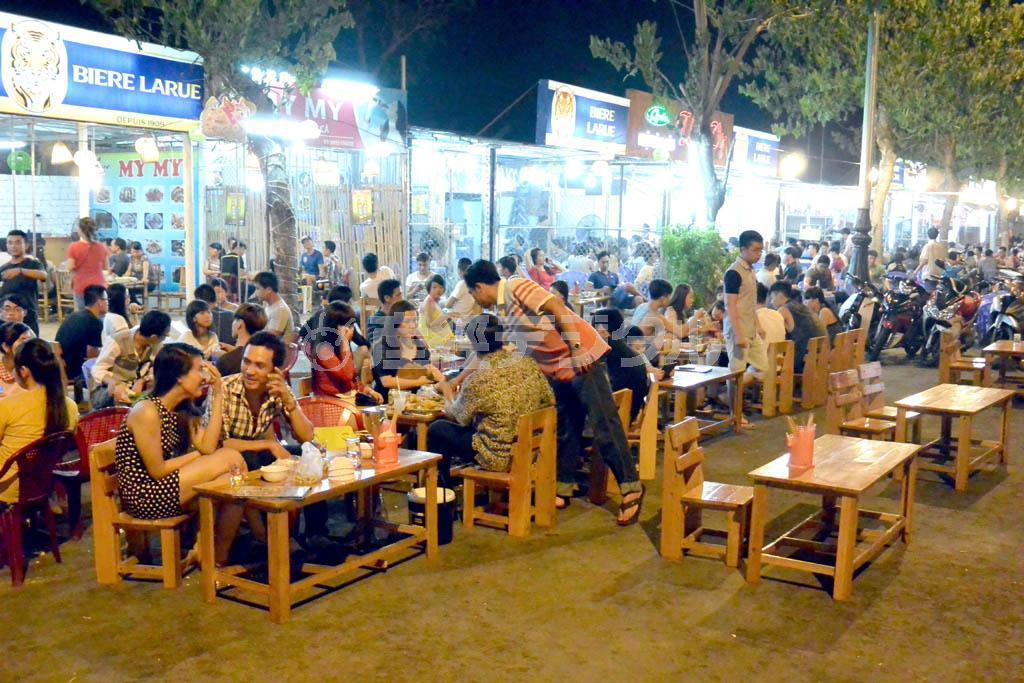 路上にテーブルと椅子を出したドラゴンブリッジ周辺の飲食店は大変なにぎわいを見せていた＝ベトナム中部のダナン