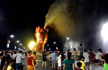 鋼鉄製ドラゴンが大量の水を吐き出し、逃げ惑う見物人ら＝ベトナム中部のダナン（長浜明宏撮影）