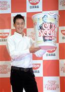 自身の写真がプリントされた記念パッケージカップヌードルのレプリカを持ち、写真撮影に応じる錦織圭＝１６日午前、東京都新宿区新宿（川口良介撮影）