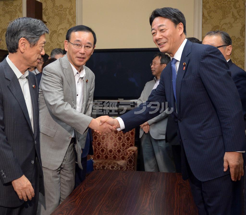 自民党新執行部の発足を受け、谷垣禎一（さだかず）新幹事長（左から２人目）と握手を交わす民主党の海江田万里（かいえだ・ばんり）代表（右）。政党党首としては安倍晋三（しんぞう）首相より１日早く就任した海江田氏だが、精彩を欠いている＝２０１４年９月９日午後、国会内（酒巻俊介撮影）