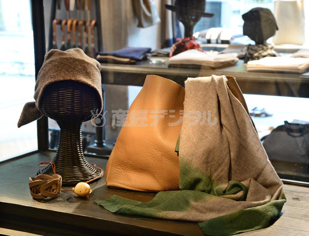 カシミア１００％のストール（３万４０００円）は縁を染めた素朴な味わい。革を裁ち切りにしたバッグと合わせると秋らしいおしゃれに。※価格はすべて税別です＝２０１４年９月４日、東京都港区（寺河内美奈撮影）