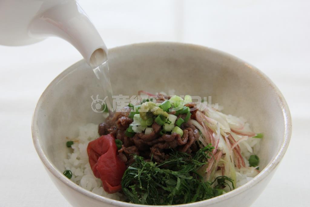 牛しぐれ煮のだし茶漬け（作り方２）＿＿器にごはんを入れて（作り方１：調理した牛しぐれ煮）の牛肉をのせ、薬味と野菜をのせて最初はそのまま食べる。次にだしを加え、梅干し、わさびなどを添えてお茶漬けで食べる。