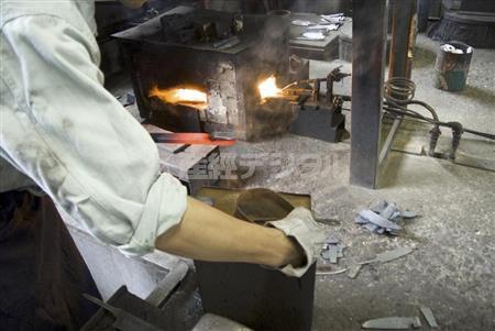 少しずつ叩いて包丁の形状を整えていく。正確さとスピードが要求される工程＝２０１４年８月２８日（提供写真）