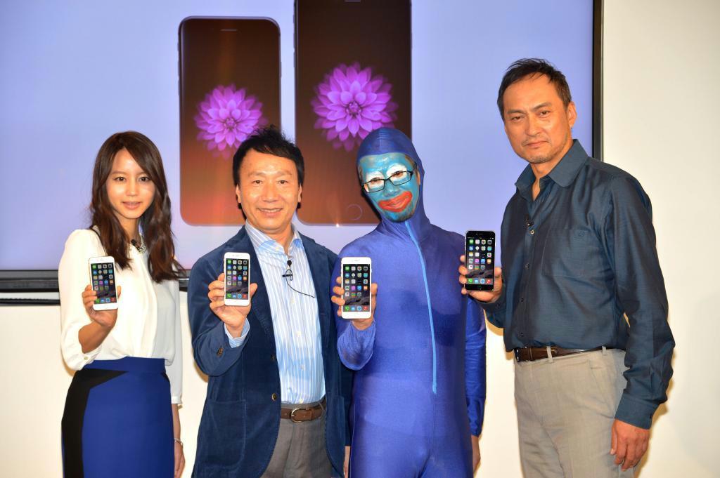 「ｉＰｈｏｎｅ６」を持つ左から女優の堀北真希さん、ＮＴＴドコモの加藤薫社長、店に一番乗りした顧客、俳優の渡辺謙さん＝１９日、東京都千代田区のドコモショップ丸の内店