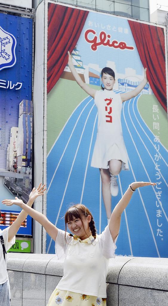 看板を前に記念撮影のためポーズをとる女性＝大阪市中央区