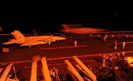 ペルシャ湾上の米空母ジョージ・ブッシュで、出撃を待つＦＡ１８戦闘攻撃機＝２０１４年９月２３日（米海軍提供・共同）