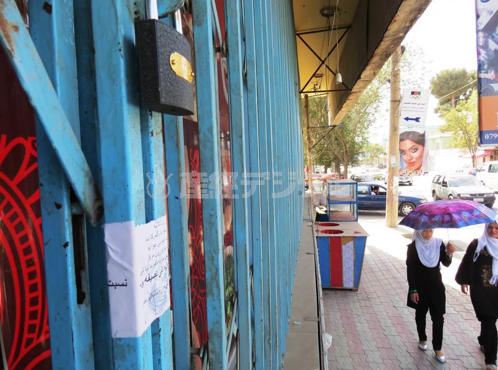 ９月２２日、アフガニスタンの首都カブールで、税務当局によって閉鎖させられた飲食店。町の道路は整備され、タリバン政権時代には禁止された女性の写真を使ったポスターは普通の風景になった。女子の就学率が上がり、多くの女子生徒が町を歩く＝２０１４年（岩田智雄撮影）