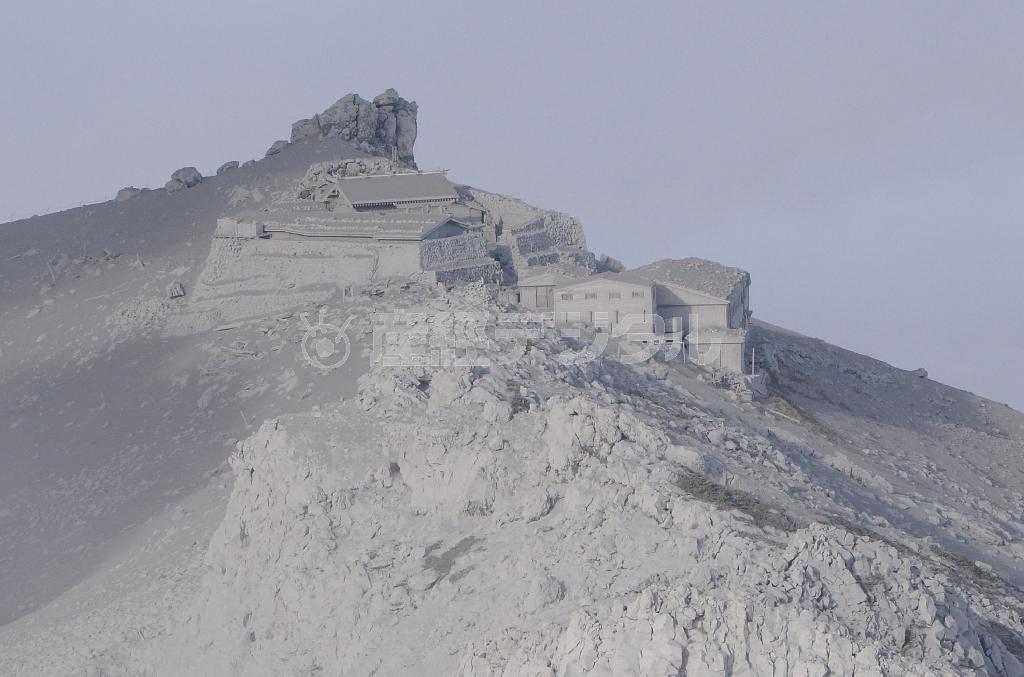 火山灰に覆われた御嶽山（おんたけさん、標高３０６７メートル）の山頂付近の山小屋＝２０１４年９月２７日午後４時８分、長野・岐阜県境（本社ヘリから、甘利慈撮影）
