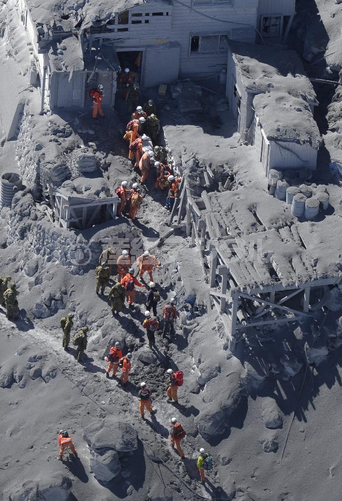 御嶽山（おんたけさん、標高３０６７メートル）山頂付近の山小屋で救助活動する消防と自衛隊員ら＝２０１４年９月２８日午前１１時５２分、長野・岐阜県境（本社へりから、甘利慈撮影）