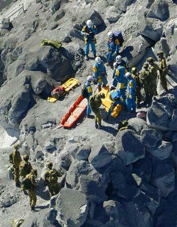 御嶽山の山頂付近で、登山者の救助作業を行う自衛隊員ら。企業も行方が分からない社員の安否確認を急いでいる＝２９日午前、共同通信社ヘリから