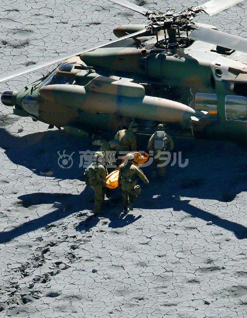 御嶽山（おんたけさん、３０６７メートル）山頂付近で、取り残された登山者をヘリコプターに運び込む自衛隊員＝２０１４年９月２９日午前１０時５０分（共同通信社ヘリから撮影）
