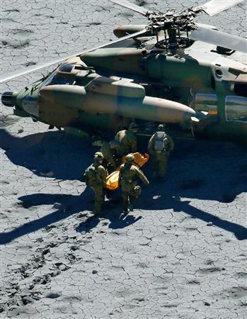 御嶽山（おんたけさん、３０６７メートル）山頂付近で、取り残された登山者をヘリコプターに運び込む自衛隊員＝２０１４年９月２９日午前１０時５０分（共同通信社ヘリから撮影）