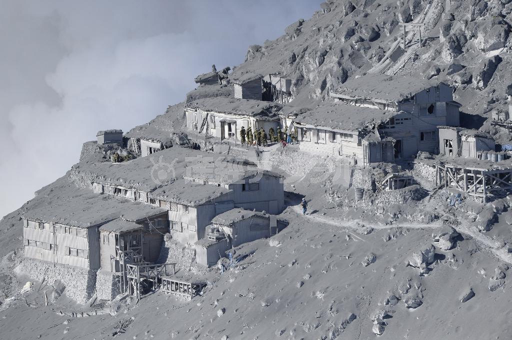 御嶽山（おんたけさん、３０６７メートル）山頂付近にある山荘も火山灰にすっぽり覆われ、捜索は困難を極めた＝２０１４年９月２９日午前、長野・岐阜県境（本社ヘリから、甘利慈撮影）