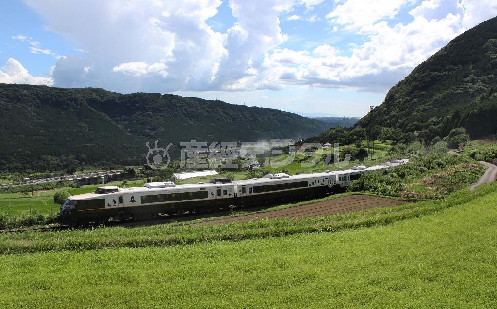 雄大な阿蘇の山間部をスイッチバックで走り抜ける４両編成の「あそぼーい」＝２０１４年７月３０日、熊本県阿蘇郡南阿蘇村（鈴木健児撮影）