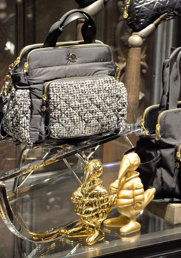 ツイードとナイロンの異なる素材をミックスしたバッグ「ペネロペ」（１３万１０００円）、手前はブランドのマスコット「モンダック」。※価格はすべて税別です＝２０１４年９月２６日、東京都港区（川口良介撮影）