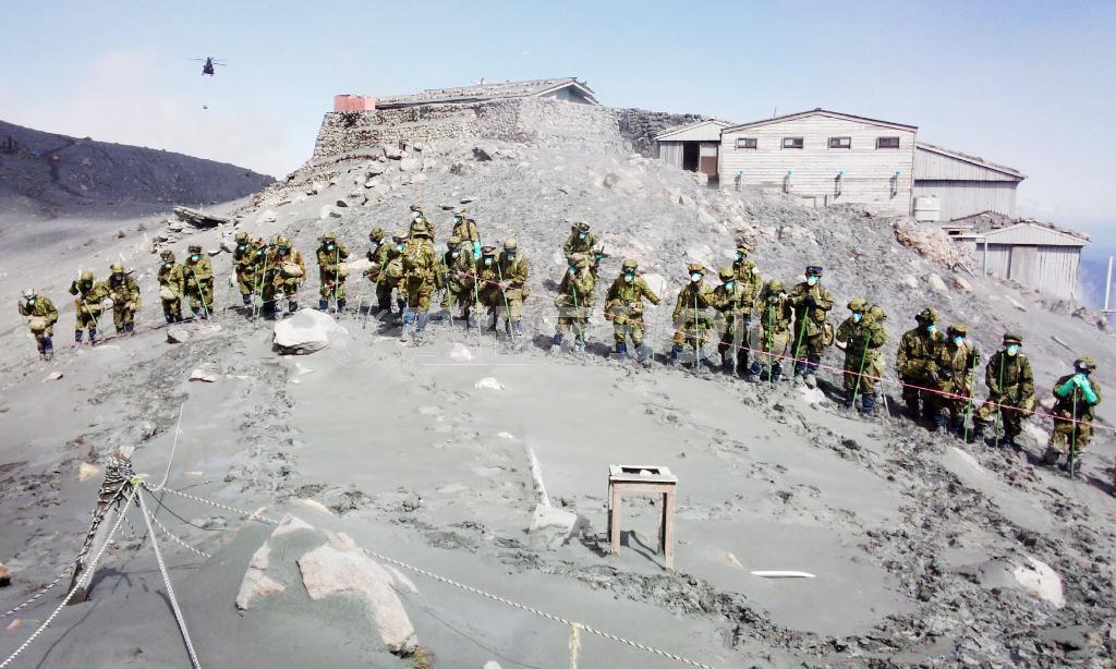 御嶽山（おんたけさん、長野・岐阜県、３０６７メートル）山頂付近で横一列になって捜索する自衛隊員＝２０１４年１０月７日正午ごろ（陸上自衛隊提供）