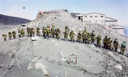 御嶽山（おんたけさん、長野・岐阜県、３０６７メートル）山頂付近で横一列になって捜索する自衛隊員＝２０１４年１０月７日正午ごろ（陸上自衛隊提供）
