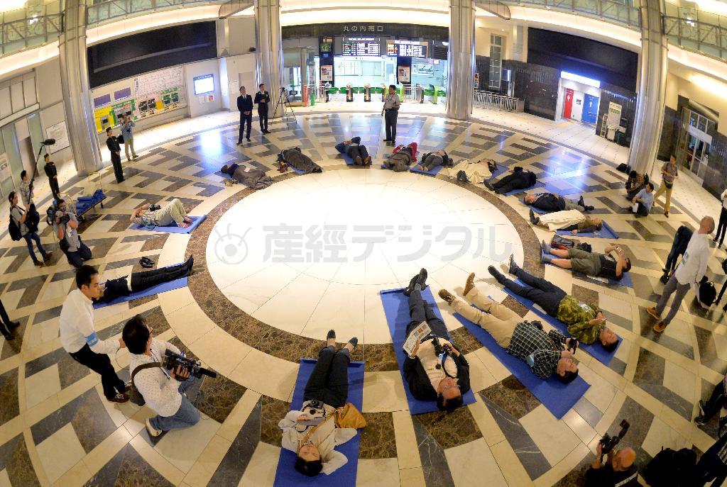 丸の内南ドームの中央部分に円形になって寝転がり、スタッフの解説に耳を傾けながら天井のレリーフや装飾を眺めるツアー参加者ら＝２０１４年１０月２日午前、東京都千代田区・ＪＲ東京駅（宮崎瑞穂撮影）