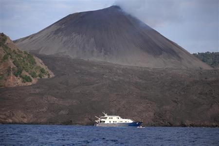 海を泳ぐゾウ、ラジャンの住むハブロック島の近くにある活火山のバレン島＝２０１０年３月２７日、インド・アンダマン諸島（越智隆治さん撮影）