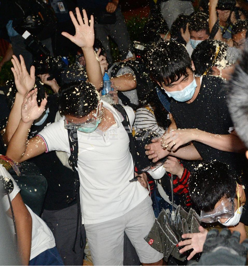 香港の警官隊に催涙スプレーをかけられる民主派のデモ隊＝２０１４年１０月１６日未明、中国・香港の行政長官弁公室前（共同）