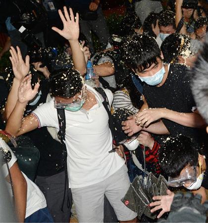 香港の警官隊に催涙スプレーをかけられる民主派のデモ隊＝２０１４年１０月１６日未明、中国・香港の行政長官弁公室前（共同）