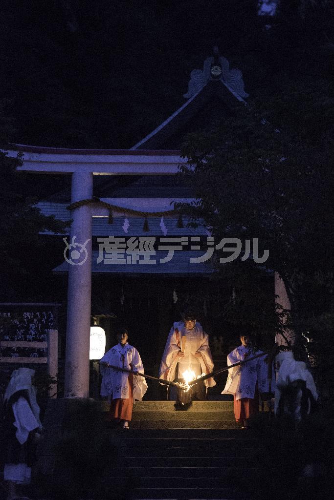 薪能奉納に先立つ火入れ式。巫女の手によりかがり火が能舞台に進む＝２０１４年１０月１１日、神奈川県鎌倉二階堂・鎌倉宮（渡辺照明撮影）