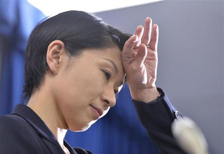 記者会見中、額に手を当てる小渕経産相＝２０日午前、経産省