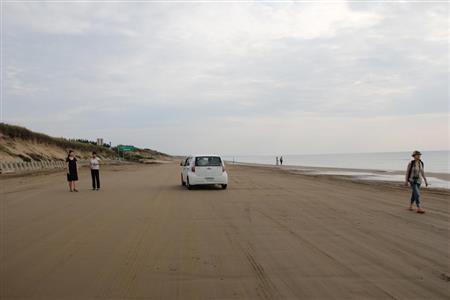 波打ち際ぎりぎりをドライブすることができる「千里浜なぎさドライブウェイ」。他の海岸よりも砂の粒子が小さく適度な海水を含んで引き締まっているため、車やバスも自由に走ることができる＝２０１４年９月３日、石川県羽咋市（田中幸美撮影）