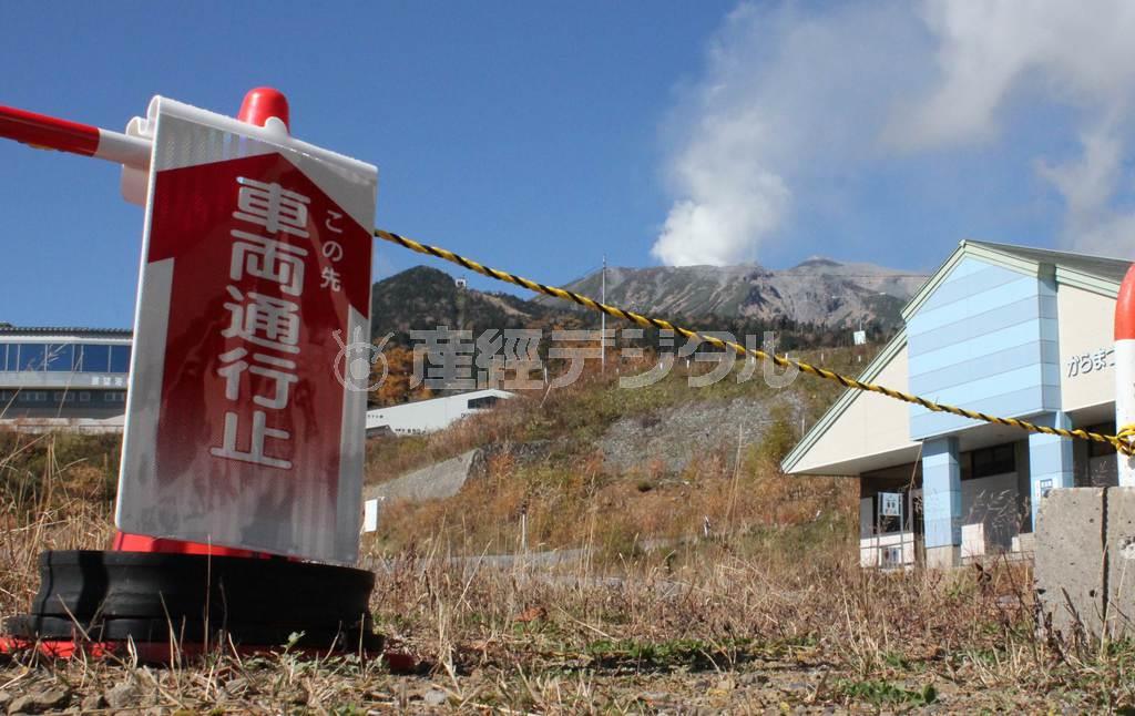 営業の見通しが立たないスキー場。入口は通行止めで、背後には噴煙を上げ続ける御嶽山（おんたけさん、３０６７メートル）が見える＝２０１４年１０月２４日、長野県木曽郡王滝村（加藤園子撮影）