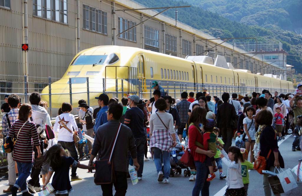 ＪＲ西日本が初めて一般公開したドクターイエローと見学者＝１９日、福岡県那珂川町の博多総合車両所