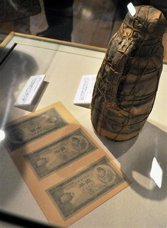 町田市民文学館ことばらんどで開催中の「尾辻克彦×赤瀬川原平」展で展示されている「梱包芸術」（右）と「模型千円札」＝東京都町田市