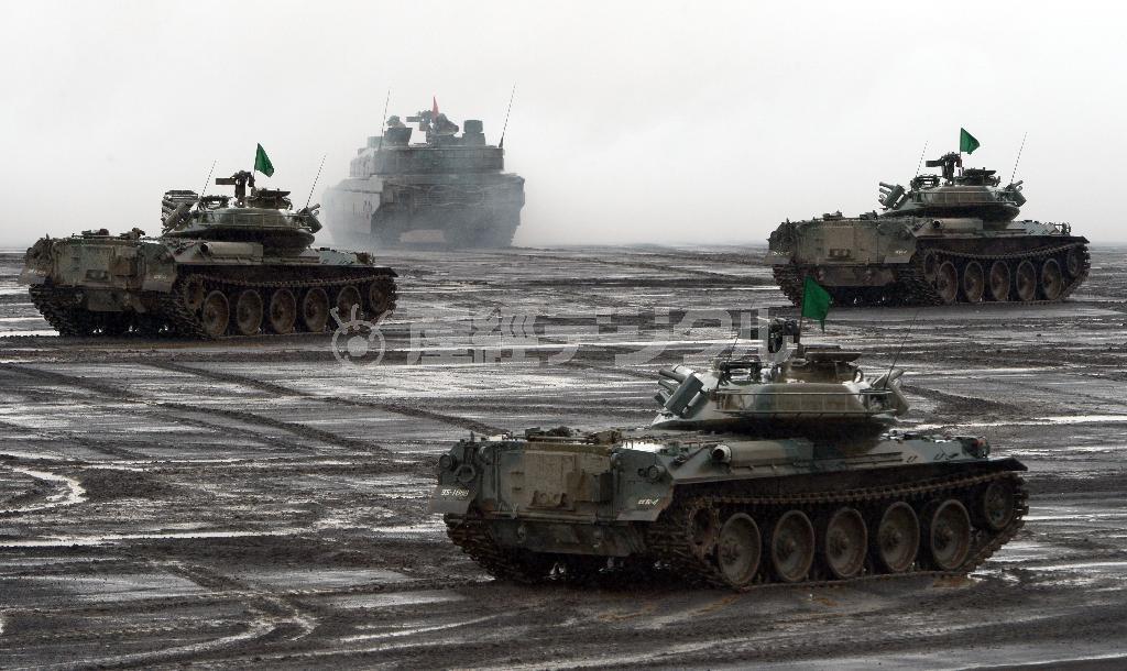 陸上自衛隊の実弾射撃訓練「富士総合火力演習」で展開する７４式戦車。自衛隊の作戦を担保する現行法は「こうあるべき」論に支配され、柔軟な即応を阻害している＝２０１４年８月２３日、静岡県の東富士演習場（酒巻俊介撮影）