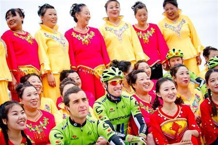 スタート地点で伝統舞踊を披露していた女性たちと記念撮影する選手たち。中国滞在を楽しむ選手が多かった＝２０１３年１０月１３日、中国・首都北京市（田中苑子さん撮影）