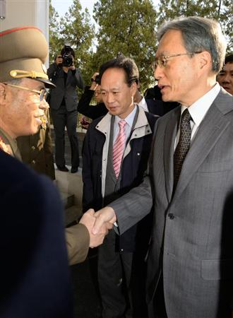 協議開始前に北朝鮮の徐大河・特別調査委員長（左）と握手する外務省の伊原純一アジア大洋州局長＝２８日午前（共同）