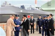 航空観閲式に出席した安倍晋三（しんぞう）首相。会場には日本が米国から導入予定の最新鋭ステルス戦闘機Ｆ３５Ａの実物大模型（奥）も展示された＝２０１４年１０月２６日、茨城県小美玉市の航空自衛隊百里基地（鈴木健児撮影）