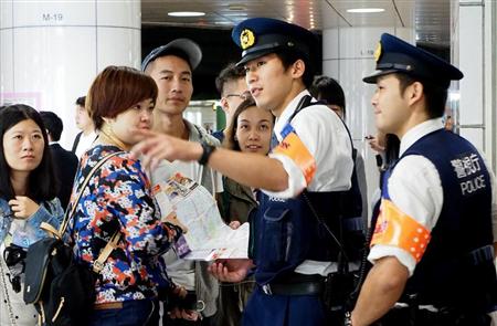東京・新宿駅で、台湾人観光客に英語混じりで道案内をする交番の警察官