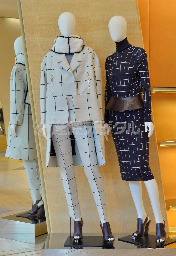 シルクやウールなどの素材を使ったウイメンズウエア。右はトップス（１３万４０００円）とスカート（８万１０００円）にカーフのベルト（８万６０００円）をあわせて。白に格子柄が粋な左はコート（３８万８０００円）にパンツ（１４万１０００円）の組み合わせ。ともにカーフのサンダル（９万９０００円）を合わせて＝２０１４年１０月２８日、東京都渋谷区のトッズ表参道ブティック（三尾郁恵撮影）