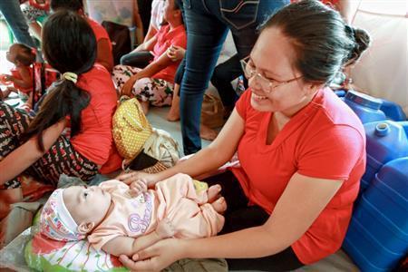 台風の６日後に生まれた男の子をあやすお母さん。ワールド・ビジョン・ジャパンは災害時でもお母さんが安心して授乳や育児ができるスペースを設置している＝２０１３年１１月１４日、フィリピン（ワールド・ビジョン・ジャパン撮影）