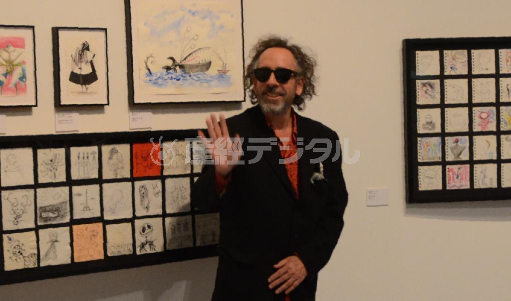 展覧会場でのティム・バートン。後ろは「アラウンド・ザ・ワールド」のスケッチ群＝２０１４年１０月３１日、東京都港区の森アーツセンターギャラリー（原圭介撮影）