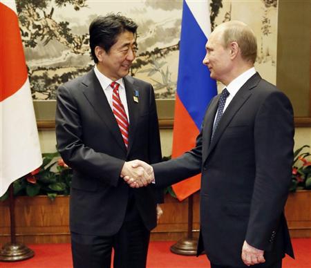 会談を前にロシアのプーチン大統領（右）と握手を交わす安倍首相＝９日、北京（共同）