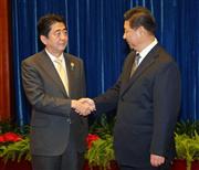 日中首脳会談を前に握手を交わす習近平国家主席（右）と安倍首相＝１０日、北京の人民大会堂（代表撮影・共同）