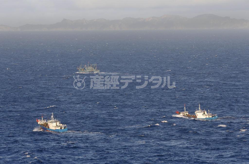小笠原諸島・父島（後方）の周辺海域を航行する中国のアカサンゴ密漁船とみられる外国漁船。中国船による密漁に、地元は「海が乗っ取られる」と警戒感を強めている＝２０１４年１１月７日午後４時１０分（共同通信社ヘリから撮影）