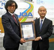 日本品質保証機構の小林憲明理事長（右）から認証書を渡されたサイバーダインの山海嘉之社長＝１２日、東京・霞が関（松村信仁撮影）