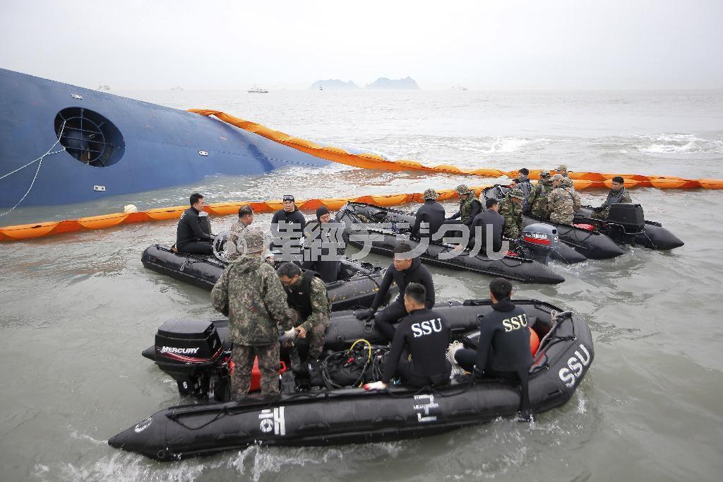 ４月１７日、転覆し、沈んでいく旅客船の近くに集まった韓国海軍の海難救助部隊の隊員たち＝２０１４年、韓国・全羅南道珍島沖（ＡＰ）