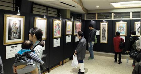 第一線で活躍する漫画家たちが描いた個性あふれるユニークな仏の絵に見入る人たち＝２０１４年１１月８日、東京都墨田区の回向院（田中幸美撮影）