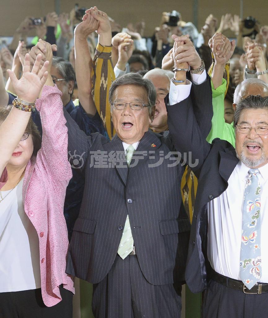 沖縄県知事選で当選を確実にし、万歳する翁長雄志（おなが・たけし）氏（中央）＝２０１４年１１月１６日夜、沖縄県那覇市（共同）