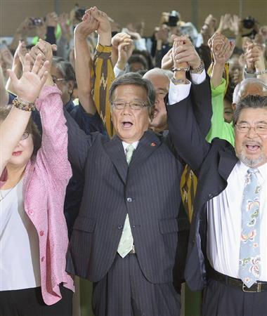 沖縄県知事選で当選を確実にし、万歳する翁長雄志（おなが・たけし）氏（中央）＝２０１４年１１月１６日夜、沖縄県那覇市（共同）