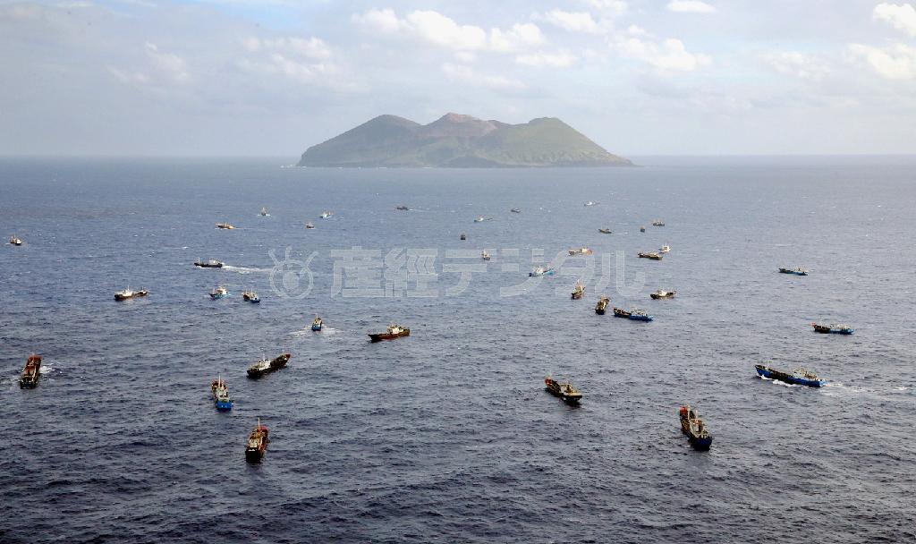 伊豆諸島・鳥島（奥）の周辺でサンゴの密漁を行う中国船籍と見られる「漁船」の群れ。中国船の密漁は反復され、侵略の先兵と化している＝２０１４年１０月３１日（共同通信社ヘリから撮影）