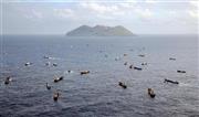 伊豆諸島・鳥島（奥）の周辺でサンゴの密漁を行う中国船籍と見られる「漁船」の群れ。中国船の密漁は反復され、侵略の先兵と化している＝２０１４年１０月３１日（共同通信社ヘリから撮影）