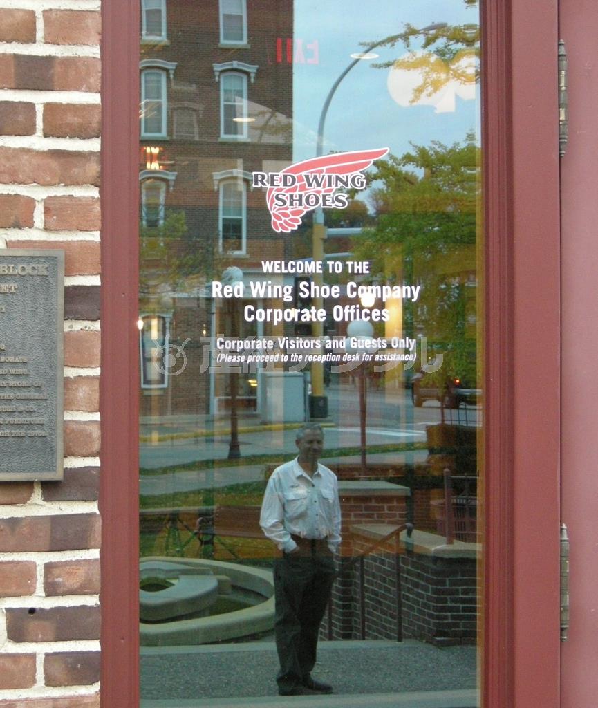 レッド・ウィングの本社、ガラス越しに映っている３代目オーナーのビル・スウィージーさん＝米ミネソタ州レッド・ウィング（藤沢志穂子撮影）